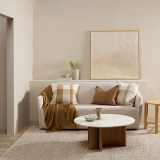 Modern living room with a beige sofa, coffee table, and decorative elements.