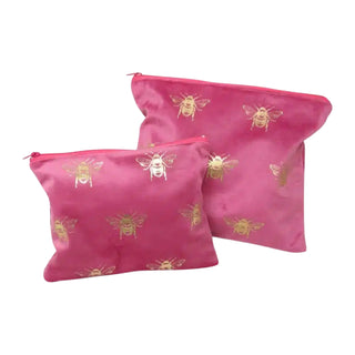 Two pink pouches with bee designs on a white background