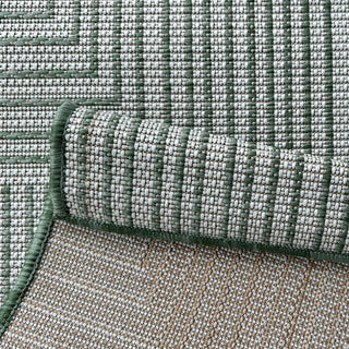 Close-up of a textured green and beige rug with a rolled edge.