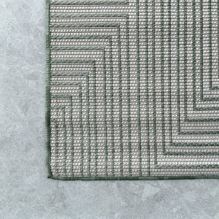 Close-up of a geometric patterned rug on a textured surface