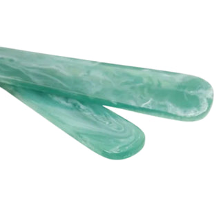 Two green marbled objects on a white background