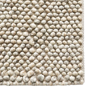 Close-up of a textured beige rug with a white background