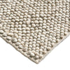 Close-up of a textured beige rug with a white background