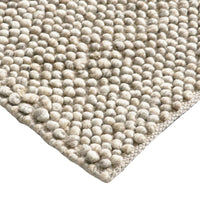 Close-up of a textured beige rug with a white background
