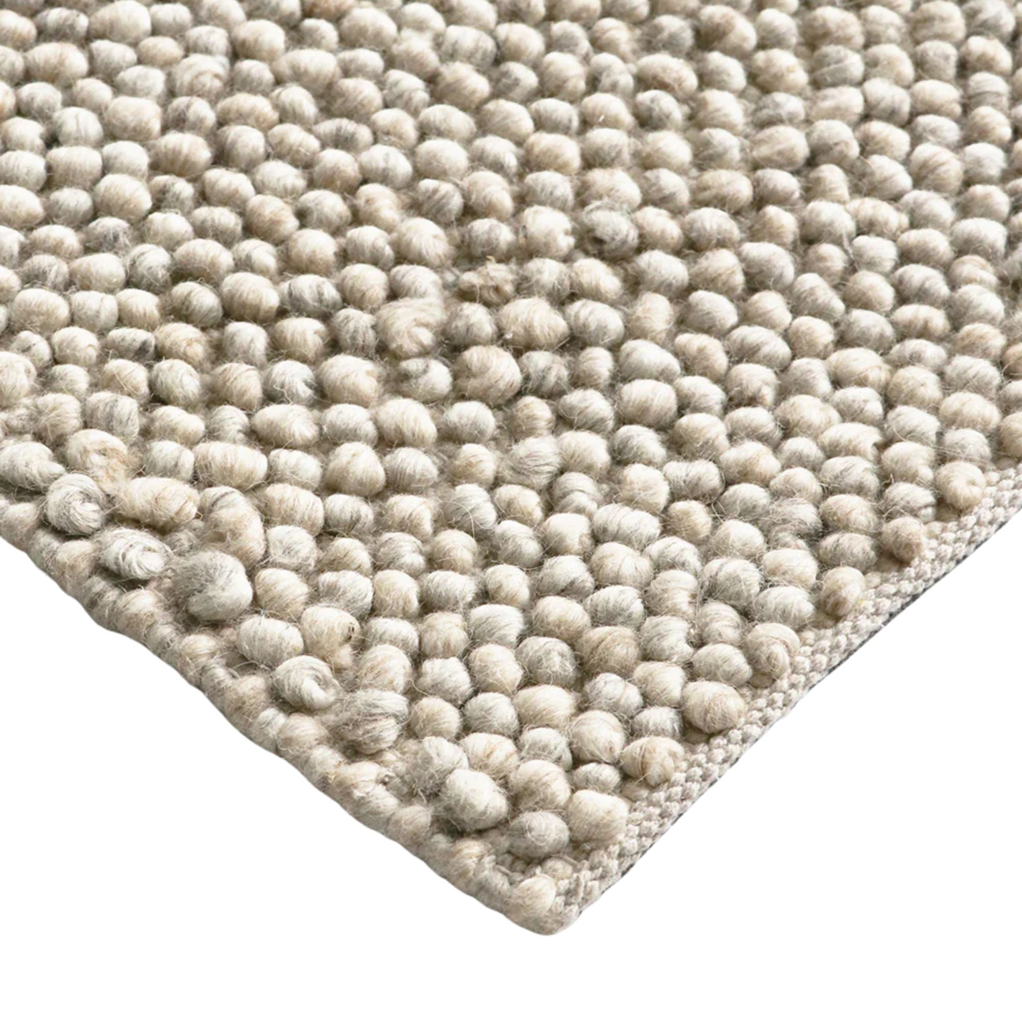 Close-up of a textured beige rug with a white background