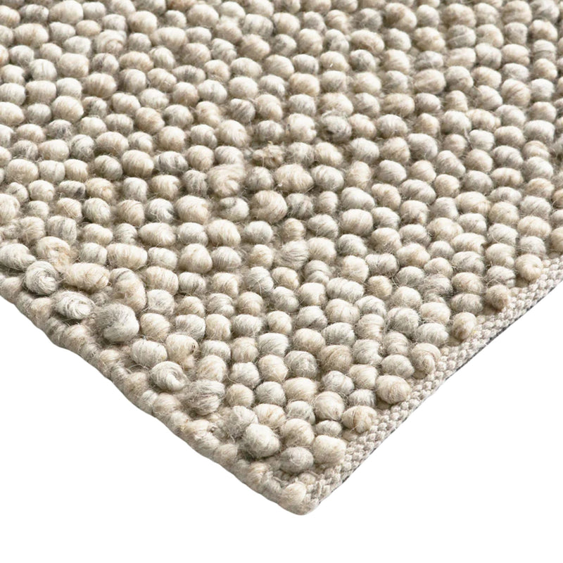 Close-up of a textured beige rug with a white background