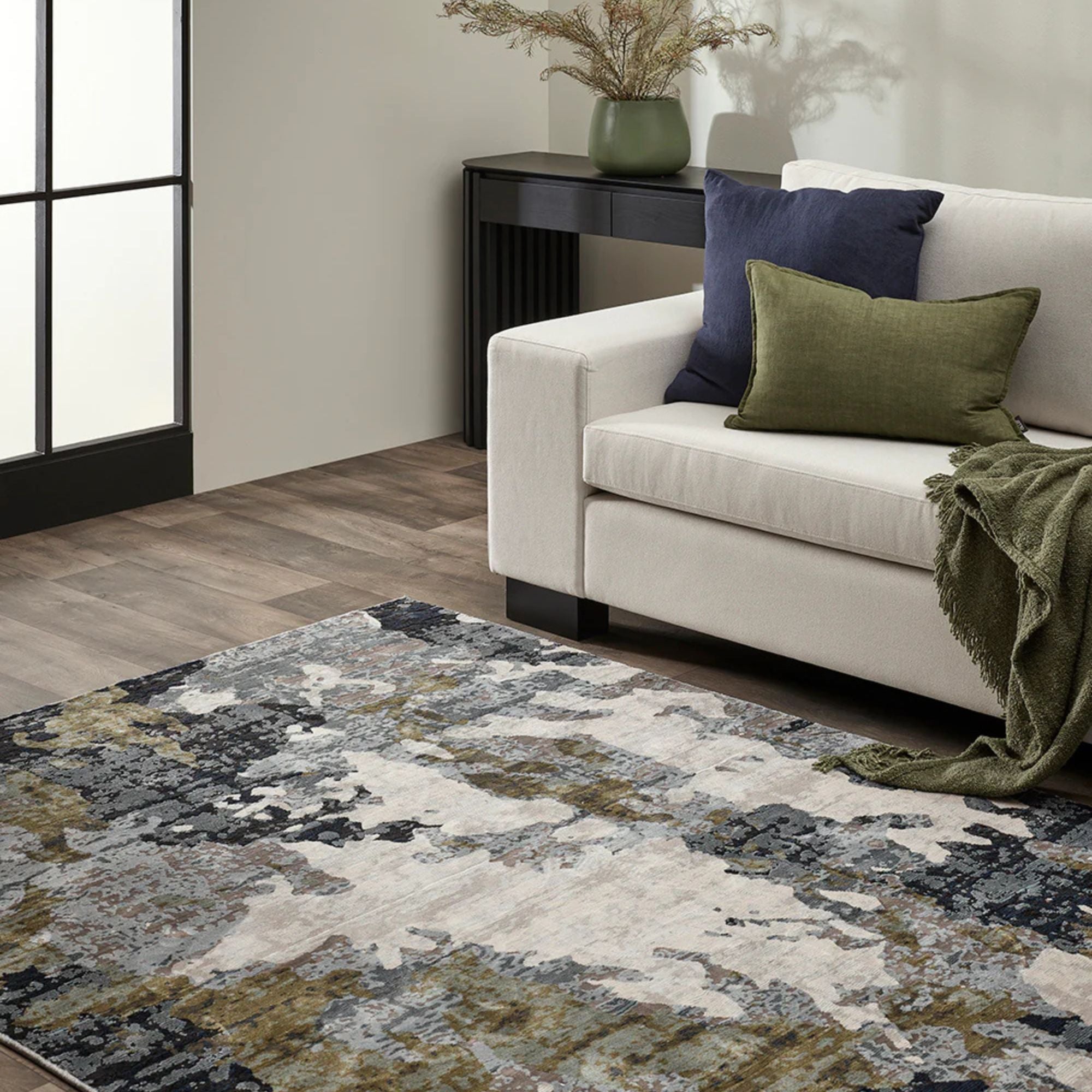 Living room with a patterned rug, beige sofa, and decorative pillows.