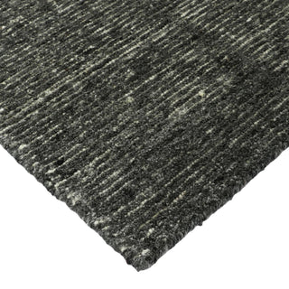 Close-up of a textured gray rug corner on a white background