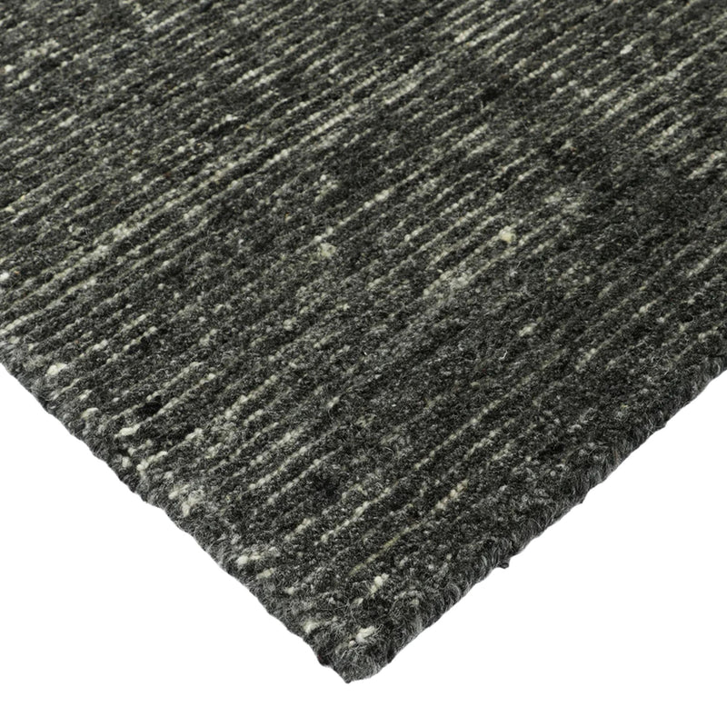 Close-up of a textured gray rug corner on a white background