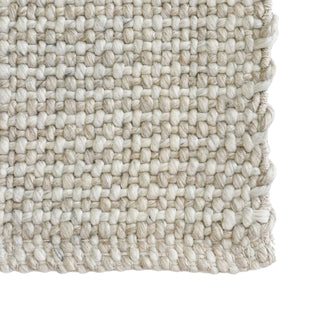 Close-up of a textured beige rug on a white background