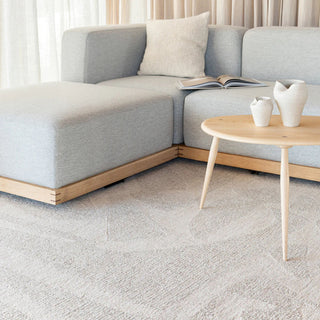 Gray sectional sofa with a wooden coffee table and decorative items in a living room setting.