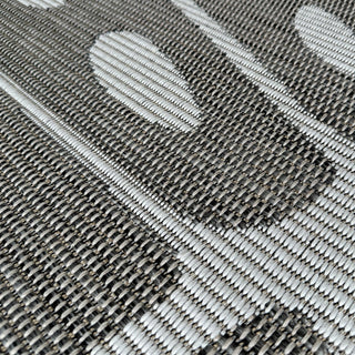 Close-up of a woven fabric with a geometric pattern in gray and white.