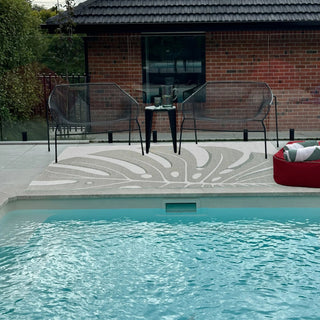 Pool area with patio furniture and a brick building in the background
