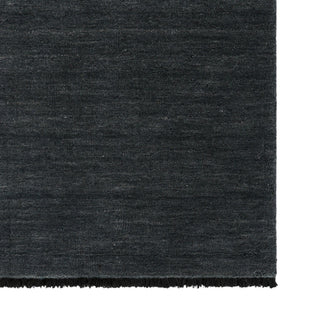 Dark gray textured rug corner on a white background