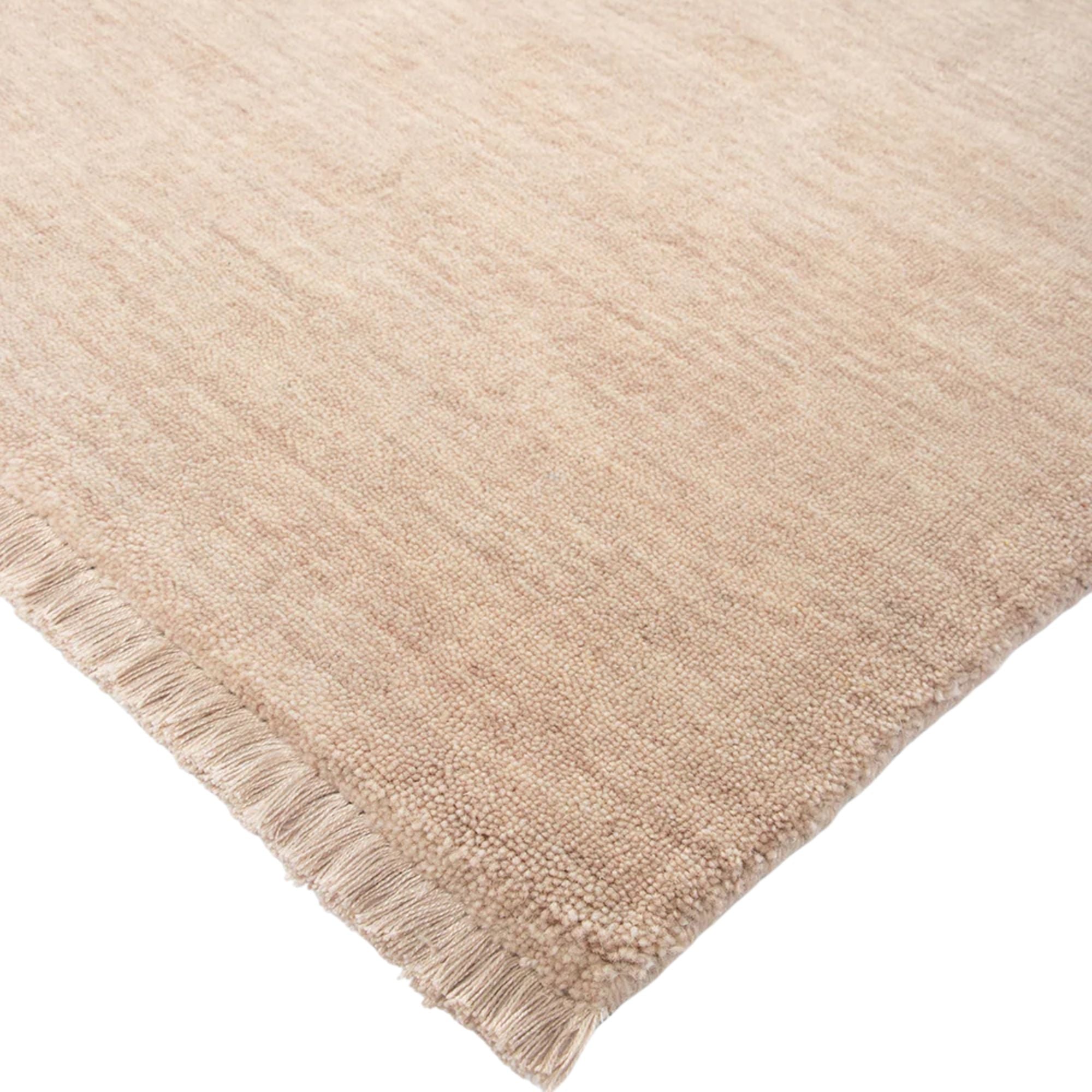 Beige rug with fringes on a white background