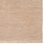 Beige woven rug with a textured pattern on a white background