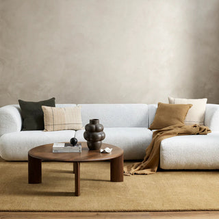 Modern living room with a white sofa, wooden coffee table, and decorative items.
