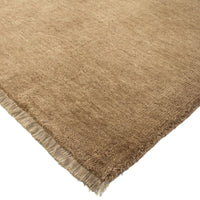 Brown textured rug with frayed edge on a white background
