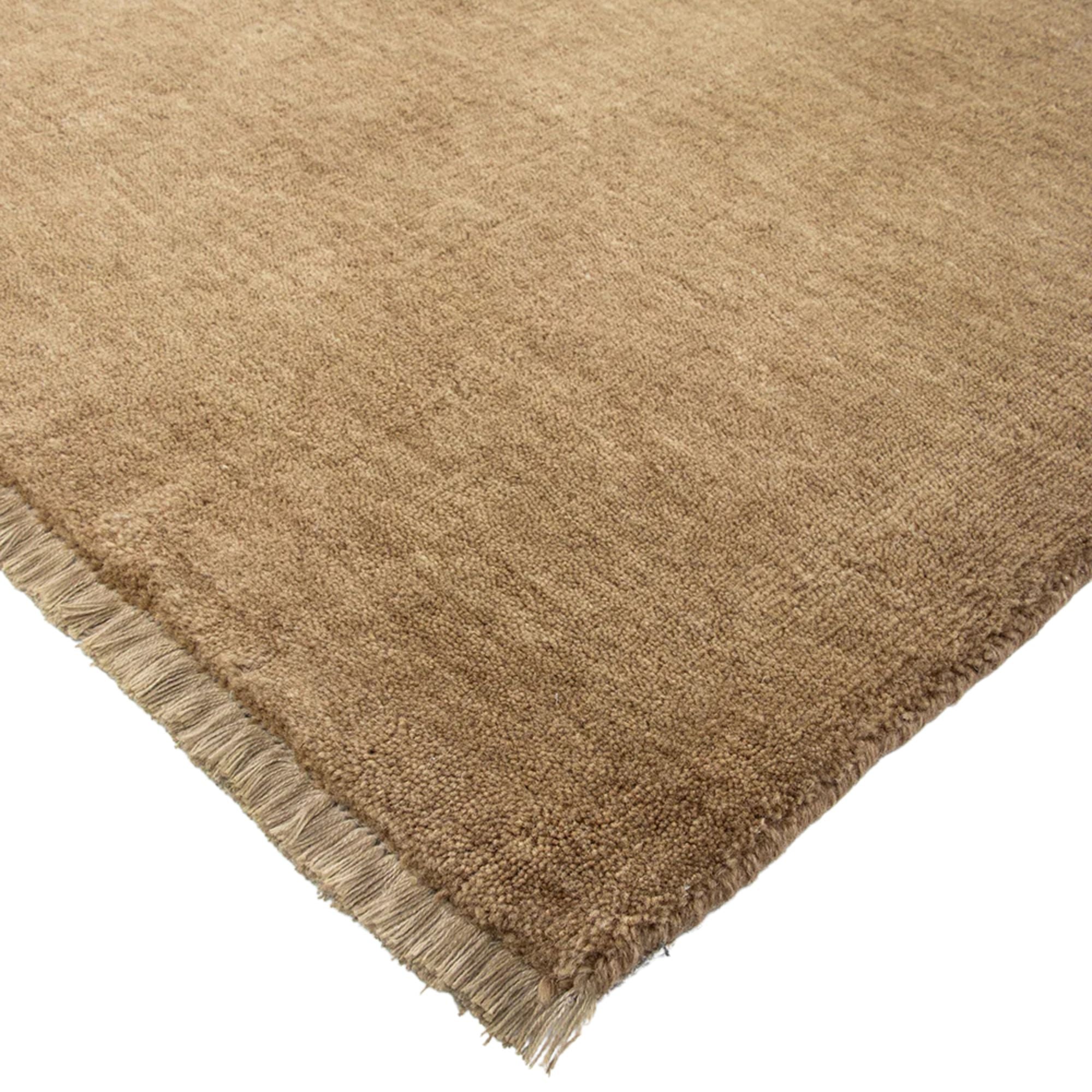 Brown textured rug with frayed edge on a white background