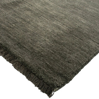 Dark gray rug with fringed edge on a white background