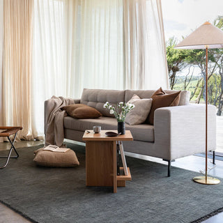 Modern living room with a gray sofa, wooden coffee table, and decorative pillows.