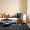 Modern living room with a white sofa, decorative pillows, and a coffee table.