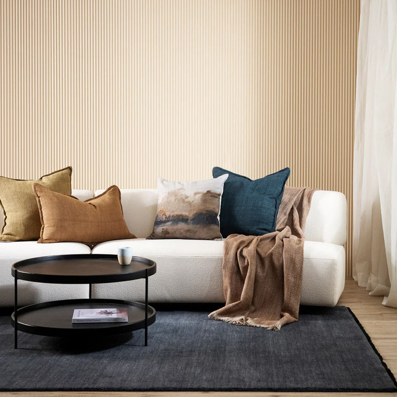 Modern living room with a white sofa, decorative pillows, and a coffee table.