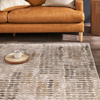 Brown leather sofa with a patterned rug and a small round table in a room.