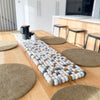 Neutral felt ball table runner styled on a wooden dining table with round placemats