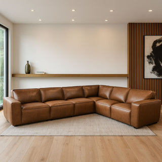 Brown leather sectional sofa in a modern living room with wooden floor and white walls.