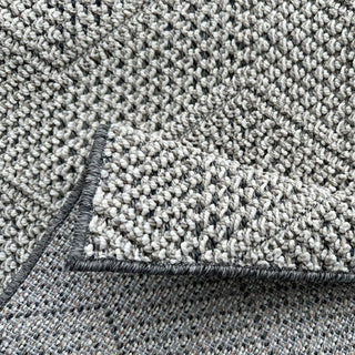 Close-up of a textured gray carpet with a visible border.