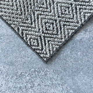 Gray geometric patterned rug on a concrete floor