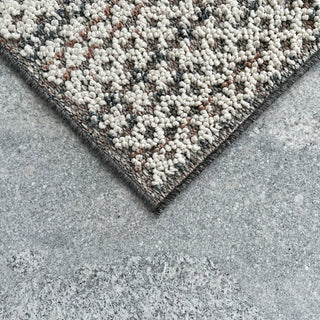 Textured rug corner on a concrete floor