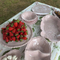 Close_up_of_French_Pink_pearl_bowls_and_platters_styled_with_fresh_fruit_on_a_table