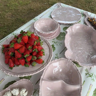 Close_up_of_French_Pink_pearl_bowls_and_platters_styled_with_fresh_fruit_on_a_table