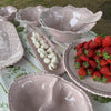 French Pink melamine pearl salad servers styled with matching serveware and fresh strawberries