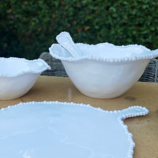 White melamine pearl bowl on outdoor table with matching salad servers