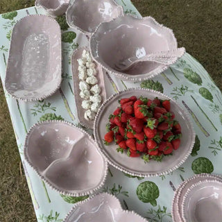 Close-up of French Pink melamine pearl serveware collection on table – salad servers included