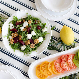 White melamine pearl bowl on outdoor table with matching salad servers