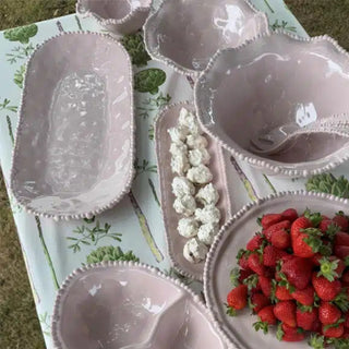 French Pink melamine pearl platter styled with matching bowls and fresh strawberries on an outdoor table