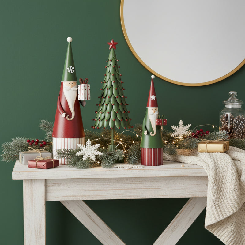Christmas-themed decor with gnomes, trees, and lights on a wooden table against a green wall.