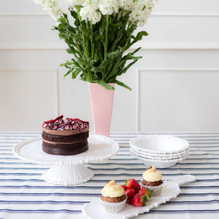 White melamine pearl bowl styled with cake and matching serveware on striped table
